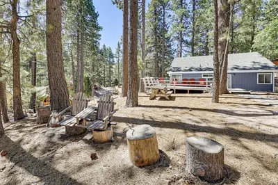 a cabin in the woods with benches and trees at Swim, Ski and Explore Cabin in Green Valley Lake! in Green Valley Lake