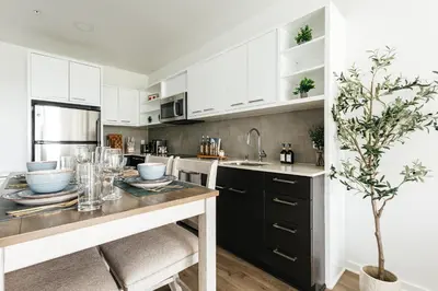 a kitchen with white cabinets and a table with a tree at Superior 2 bedroom apartment in Heart of Hollywood in Los Angeles
