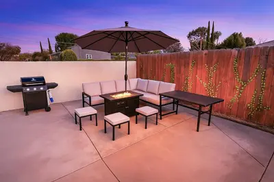 a patio with a table and chairs and an umbrella at Stylish 3BR Getaway plus Pool in Tarzana