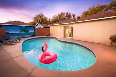 a swimming pool with a red swan in the water at Stylish 3BR Getaway plus Pool in Tarzana