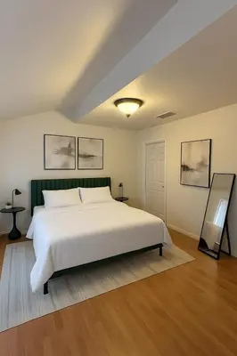 a bedroom with a large white bed and two paintings at Modern Comfort near Universal in Los Angeles