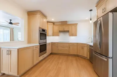 a kitchen with wooden cabinets and stainless steel appliances at Fullerton Fairytale Vacation Home - 10 Min Drive to Disneyland in Fullerton