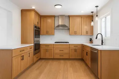 a kitchen with wooden cabinets and stainless steel appliances at Fullerton Adventure Basecamp - Short Trip To Disneyland in Anaheim