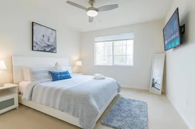 a white bedroom with a bed and a tv at Marina del Rey Coastal 2BR Retreat- Pool, Hot Tub, Gym in Los Angeles