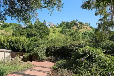 a path leading up a hill with trees and bushes at Malibu Beach - Nature 2BR Retreat in Malibu