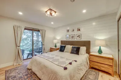 a bedroom with a large bed and a window at Stunning Forest Views Luxury Lake Arrowhead Cabin in Lake Arrowhead