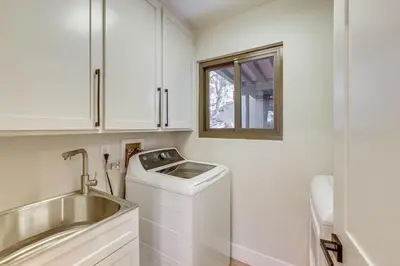 a kitchen with a washing machine and a sink at Stunning Forest Views Luxury Lake Arrowhead Cabin in Lake Arrowhead