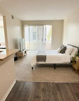 a bedroom with a large bed and a kitchen at Sunny Marina Del Rey Apartment- Hot Tub, Game Room, BBQ, Projector in Los Angeles