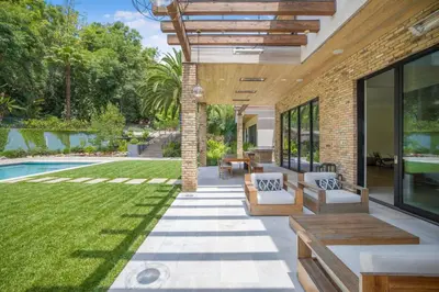 an outdoor patio with a pool and grass at Bowmont in Los Angeles