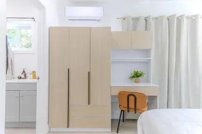 a bedroom with a wooden cabinet and a desk at Cozy & Brand New 3BR Home in West Covina in West Covina