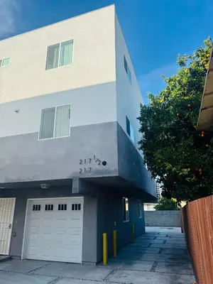 a white and blue building with two garage doors at The Ostel in Los Angeles