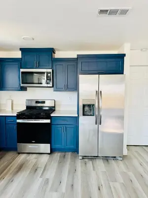 a kitchen with blue cabinets and a refrigerator at The Ostel in Los Angeles