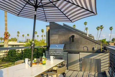 a patio with a table and an umbrella at Venice House w Pool Spa Home Theater Rooftop in Los Angeles