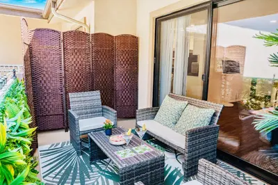 a balcony with chairs and a couch and a table at Luxury Pool View Spa Suite-Massage Chair-Steam Sauna-Welcome Champagne ! in Westlake Village