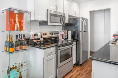 a kitchen with white cabinets and stainless steel appliances at Luxury Pool View Spa Suite-Massage Chair-Steam Sauna-Welcome Champagne ! in Westlake Village