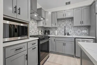 a kitchen with white cabinets and stainless steel appliances at Stylish Cozy getaway in West Valley Area Heliport