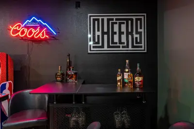 a bar with bottles of alcohol and a neon sign at Summit Haven: Game Room | Sauna | Spa | 1/4 Acre in Big Bear Lake