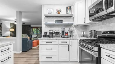 a kitchen with white cabinets and a stove top oven at 5BDR Stay w Fireplace Game room Family-Friendly Amenities Arrowhead Chalet by AvantStay in Lake Arrowhead