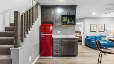 a red refrigerator in a living room with a staircase at 5BDR Stay w Fireplace Game room Family-Friendly Amenities Arrowhead Chalet by AvantStay in Lake Arrowhead