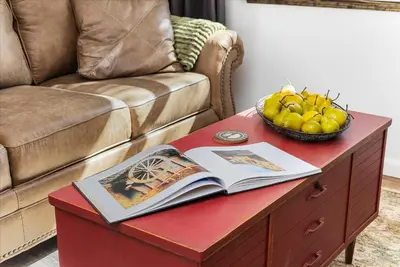 a red coffee table with a book and a bowl of fruit at The Petite-Villas at Dorner Family Vineyard in Tehachapi