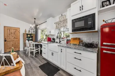 a kitchen with white cabinets and a red refrigerator at The Petite-Villas at Dorner Family Vineyard in Tehachapi