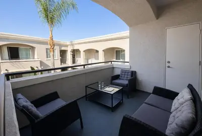 a balcony with couches and a table and a palm tree at Marina Del Rey Beach Retreat w Hot Tub, Billiards & Grill in Los Angeles