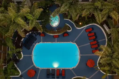 an overhead view of a resort swimming pool with palm trees at Marina Del Rey Beach Retreat w Hot Tub, Billiards & Grill in Los Angeles