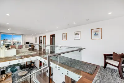 a glass staircase in a living room at ocean front beach house in Oxnard