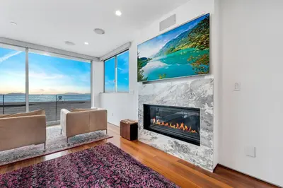 a living room with a fireplace and a large painting at ocean front beach house in Oxnard