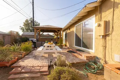 a backyard patio with a picnic table in front of a house at Fullerton Family-Ready- 9 min to Disneyland in Fullerton