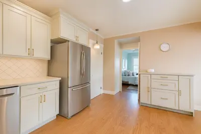 a kitchen with white cabinets and a stainless steel refrigerator at Fullerton Adventure Pad - 10 min to Disneyland in Fullerton