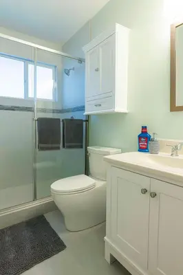 a white bathroom with a toilet and a shower at Fullerton Parkside Getaway - 13min to Disneyland in Fullerton