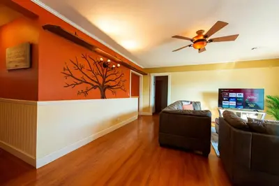 a living room with a couch and a ceiling fan at Fullerton Parkside Getaway - 13min to Disneyland in Fullerton