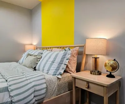 a bedroom with a bed and a table with a lamp at Dondo Stay in Los Angeles