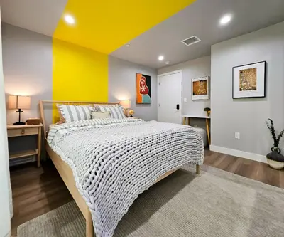 a bedroom with a large bed with a yellow wall at Dondo Stay in Los Angeles