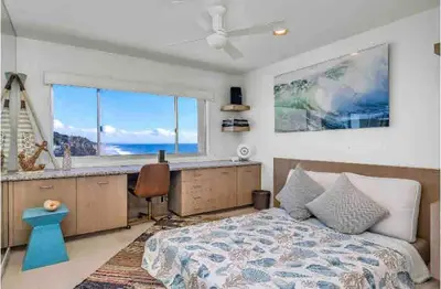a bedroom with a bed and a desk and a window at Oceanfront, Pool, Jacuzzi NO HWY Noise! in Malibu Beach