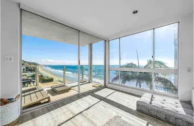 a large living room with a view of the ocean at Oceanfront, Pool, Jacuzzi NO HWY Noise! in Malibu Beach