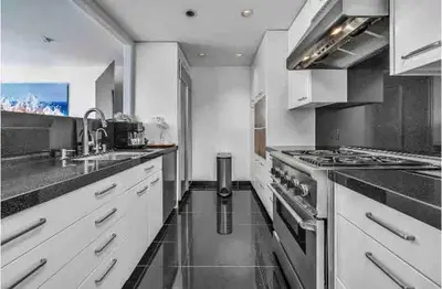 a kitchen with white cabinets and stainless steel appliances at Oceanfront, Pool, Jacuzzi NO HWY Noise! in Malibu Beach