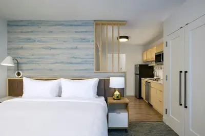a bedroom with a bed and a kitchen at TownePlace Suites by Marriott Ridgecrest in Ridgecrest