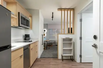a kitchen with white countertops and a door to a room at TownePlace Suites by Marriott Ridgecrest in Ridgecrest