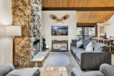 a living room with a couch and a fireplace at Switzerland Summit Condo- Cozy Base Camp Resort Chalet- Walk to Ski Lifts + Hiking in Big Bear Lake