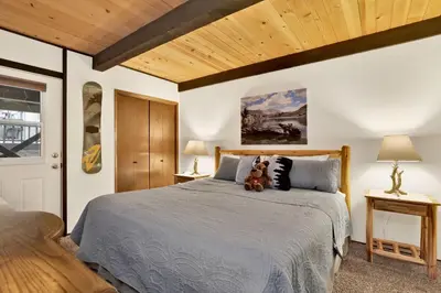 a bedroom with a bed with a teddy bear on it at Switzerland Summit Condo- Cozy Base Camp Resort Chalet- Walk to Ski Lifts + Hiking in Big Bear Lake