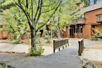 a park with a bench next to a building at Switzerland Summit Condo- Cozy Base Camp Resort Chalet- Walk to Ski Lifts + Hiking in Big Bear Lake