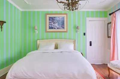 a bedroom with green striped walls and a bed at Central Hollywood Homestay Getaway in Los Angeles