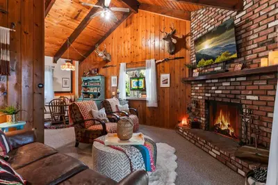 a living room with a fireplace and a brick wall at Retro Retreat, BBQ, Patio with Outdoor Seating! in Lake Arrowhead