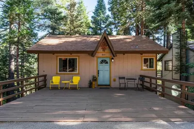 a tiny house with a porch and yellow chairs at Retro Retreat, BBQ, Patio with Outdoor Seating! in Lake Arrowhead