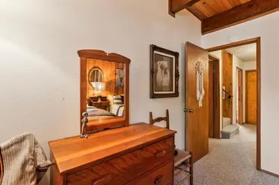 a bedroom with a wooden dresser and a mirror at Retro Retreat, BBQ, Patio with Outdoor Seating! in Lake Arrowhead
