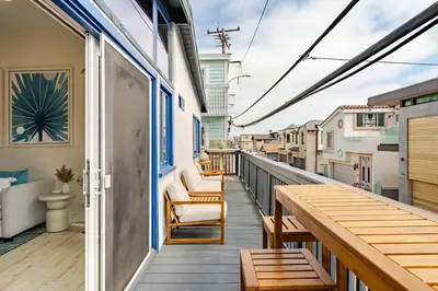 a balcony with chairs and a table on a building at Amazing location, Unique Oceanfront Beach House! in Manhattan Beach