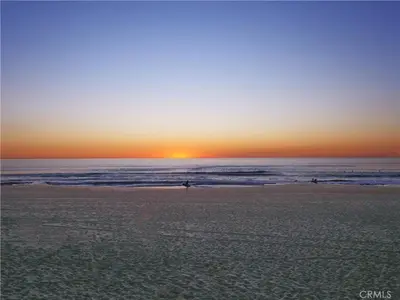 a group of people walking on the beach at sunset at Amazing location, Unique Oceanfront Beach House! in Manhattan Beach