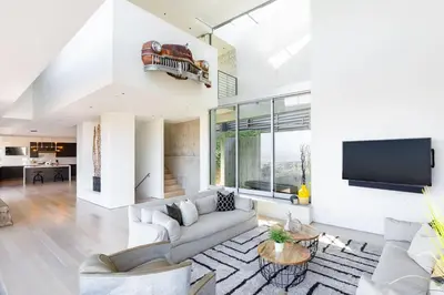 a living room with white furniture and a flat screen tv at Modern Villa Hollywood Hills Sanctuary in Los Angeles